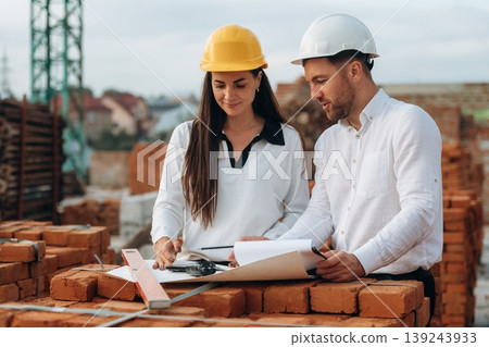 Female manager and male builder are on the construction site Female manager and male builder are on the construction site 139243933