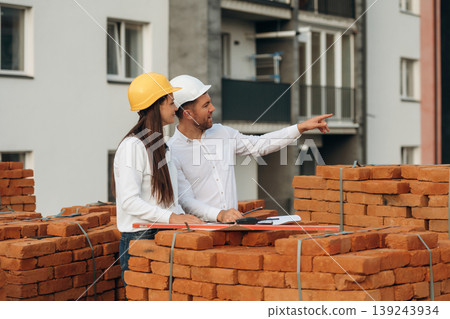 Female manager and male builder are on the construction site Female manager and male builder are on the construction site 139243934