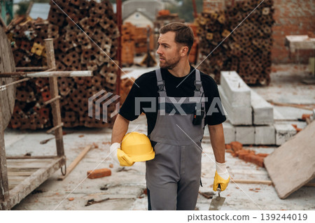 Going forward, walking. A builder is working at the construction site at daytime Going forward, walking. A builder is working at the construction site at daytime 139244019