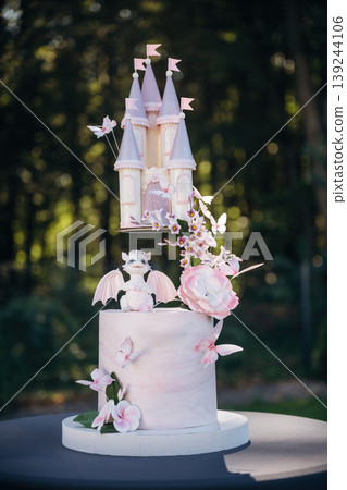 Placed outdoors. Beautiful birthday cake with dragon and castle, delicious meal, natural lighting 139244106