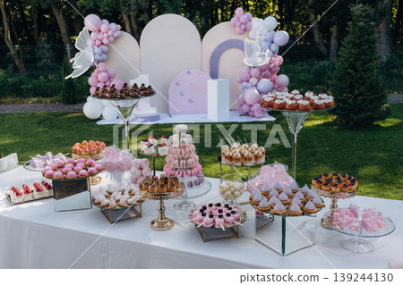 Pedestal is behind, at background. Party table with lot of sweets, desserts. Conception of celebration 139244130