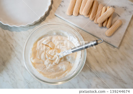 Preparing tiramisu cream with ladyfingers on marble surface top view Preparing tiramisu cream with ladyfingers on marble surface top view 139244674