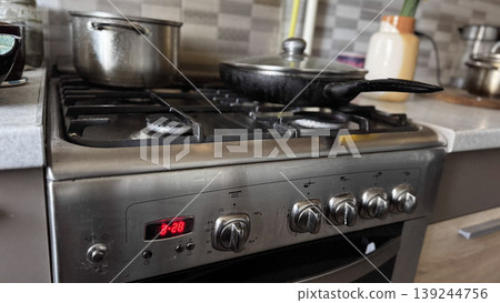 Modern Kitchen Stove with Pots and Pans in Use Modern Kitchen Stove with Pots and Pans in Use 139244756