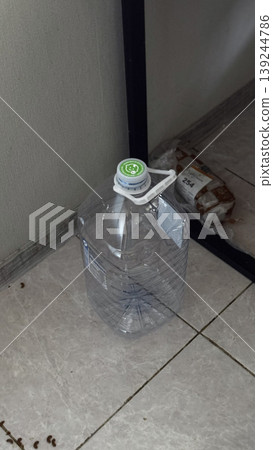 Clear Plastic Water Bottle on Floor in Indoor Setting Clear Plastic Water Bottle on Floor in Indoor Setting 139244786