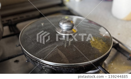Cooking with Care A Covered Pan on the Stove 139244885