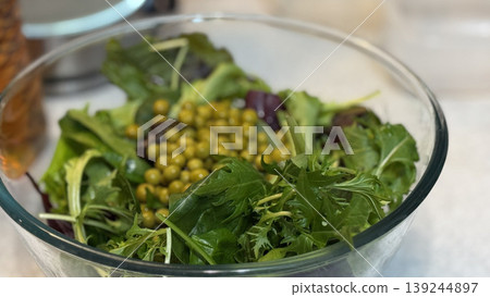 Fresh Green Salad with Peas in a Clear Bowl 139244897
