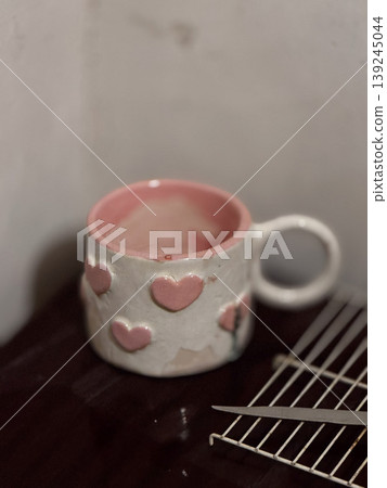 Charming Heart-Embellished Ceramic Mug on Wooden Surface Charming Heart-Embellished Ceramic Mug on Wooden Surface 139245044
