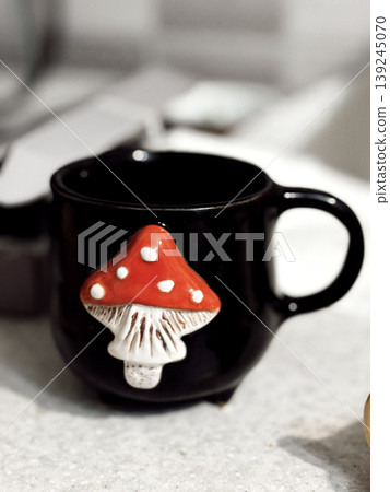 Charming Black Mug with Red Mushroom Design for Cozy Settings 139245070