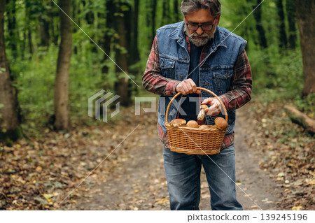 Walking, collected lot of them, in basket. Mushroom picking. Man is in the forest at daytime 139245196