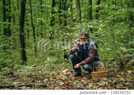 Mushroom picking. Man is in the forest at daytime Mushroom picking. Man is in the forest at daytime 139245231