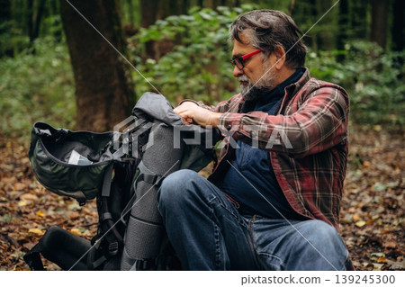 Hiking experience, senior man is in the forest at daytime Hiking experience, senior man is in the forest at daytime 139245300