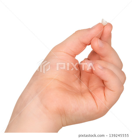 Child hand holding lost baby tooth isolated on white background tooth fairy and dental concept Child hand holding lost baby tooth isolated on white background tooth fairy and dental concept 139245555