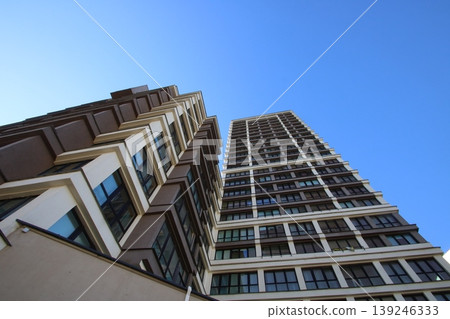 Photographer highlights sleek glass building with striking grid design against bright sky Photographer highlights sleek glass building with striking grid design against bright sky 139246333