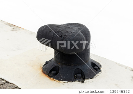Black cast-iron mooring bollard mounted on a concrete pier Black cast-iron mooring bollard mounted on a concrete pier 139246532