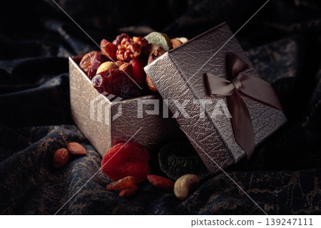 Dried tropical fruits, nuts, and raisins in gift box. Dried tropical fruits, nuts, and raisins in gift box. 139247111