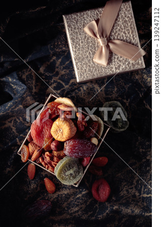 Dried tropical fruits, nuts, and raisins in gift box. Dried tropical fruits, nuts, and raisins in gift box. 139247112