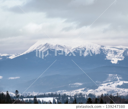 Winter evening overcast twilight mountains (Ukraine, Carpathians -  Hoverla mountain peak scenery view from Yablunytsia Pass). 139247380