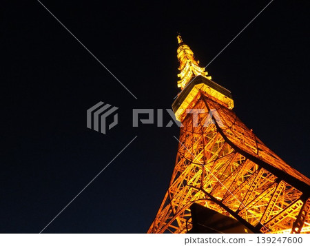 A photograph capturing Tokyo Tower at night with an oblique composition and ample negative space. 139247600