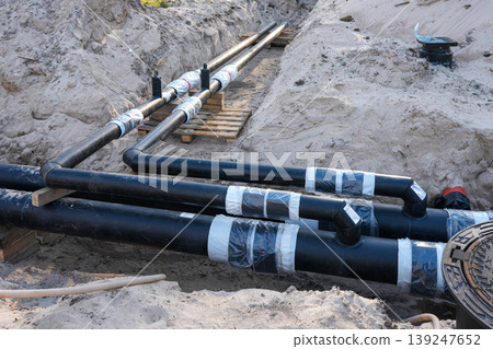 Insulated underground pipeline connections in trench for district heating utility installation site 139247652