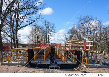 Bridge under construction with scaffolding support structure and safety rails under blue sky Bridge under construction with scaffolding support structure and safety rails under blue sky 139247660