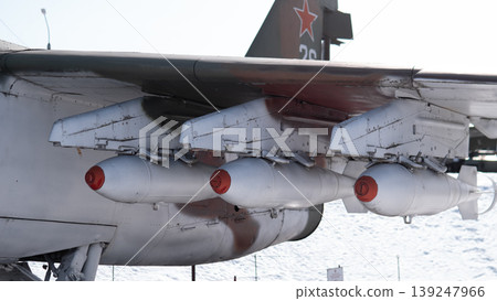 Heavy Wing Mounted Tanks And Missiles. Side View Of Tactical Aircraft Showing Multiple External Stores And Pylons With Red Star Tail Marking Snowy Airfield Backdrop And Cold Winter Light Heavy Wing Mounted Tanks And Missiles. Side View Of Tactical Aircraft Showing Multiple External Stores And Pylons With Red Star Tail Marking Snowy Airfield Backdrop And Cold Winter Light 139247966
