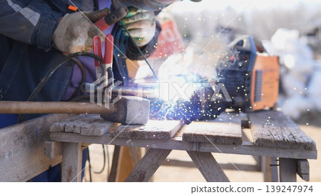 Intense Blue Flare With Sparks. Vivid Arc Illuminates Welding Process And Spark Effects Clearly. Photograph Capturing Luminous Arc And Energetic Sparks During Welding Activity Intense Blue Flare With Sparks. Vivid Arc Illuminates Welding Process And Spark Effects Clearly. Photograph Capturing Luminous Arc And Energetic Sparks During Welding Activity 139247974