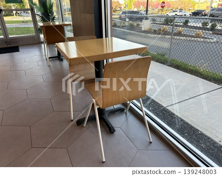 A window seat in the cafe; a simple interior with natural light streaming in. A window seat in the cafe; a simple interior with natural light streaming in. 139248003