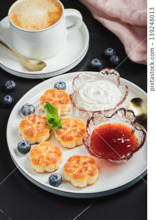 Cottage cheese pancakes, syrniki, curd fritters decorated with strawberry and raspberry served on a white plate. Homemade breakfast concept 139248013