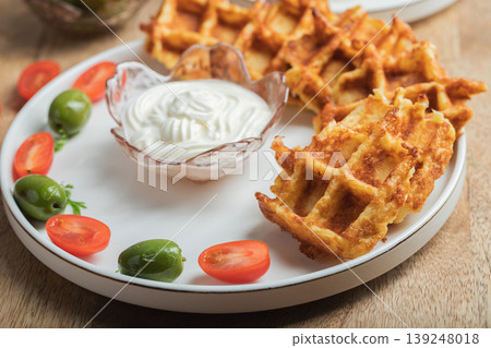 Top view of Homemade Potato Waffles, ricotta cheese and mayonese sauce. Served with tomatoes and basil leaves. Vegetarian meel Top view of Homemade Potato Waffles, ricotta cheese and mayonese sauce. Served with tomatoes and basil leaves. Vegetarian meel 139248018