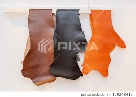 Leather hides displaying brown black and orange colors 139248415