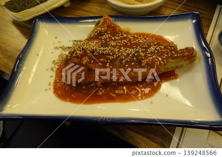 Sesame-Topped Fried Dish with Red Sauce on Plate 139248566