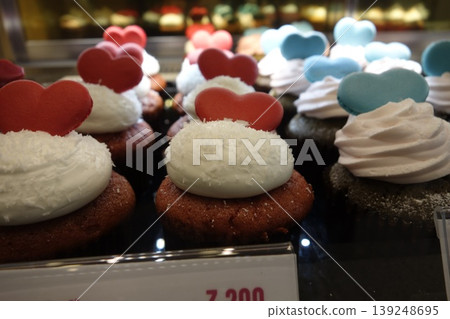 Decorated Cupcakes with Heart Toppers in Bakery Display 139248695