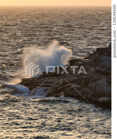 The Izu coast at sunset, with rough waves crashing against the rocky shore. The Izu coast at sunset, with rough waves crashing against the rocky shore. 139249300