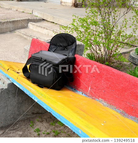 open black bag on a multicolored bench open black bag on a multicolored bench 139249518