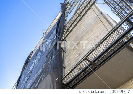 Old exterior walls and scaffolding of a detached house, immediately after construction began. Old exterior walls and scaffolding of a detached house, immediately after construction began. 139249767