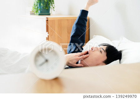 A young man oversleeps A young man oversleeps 139249970