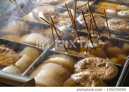 In the large oden pot inside the restaurant, ingredients such as daikon radish, konjac, chikuwa, and eggs are skewered and simmering, steaming away. 139250099