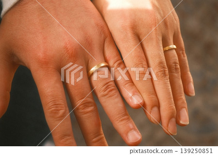 The hands of the bride and groom wearing wedding rings The hands of the bride and groom wearing wedding rings 139250851