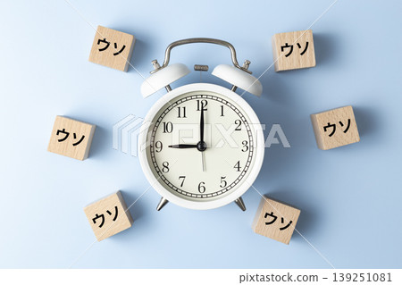 一塊寫著「謊言」字樣的積木和一個鬧鐘 一塊寫著「謊言」字樣的積木和一個鬧鐘 139251081
