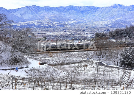 The Chuo Line train travels through snow-covered Katsunuma. 139251180