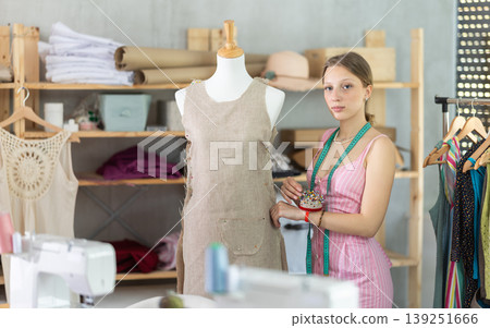 Woman seamstress adjusts clothes on mannequin Woman seamstress adjusts clothes on mannequin 139251666