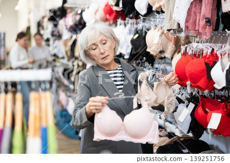 Old woman choosing convenient bra in clothing store Old woman choosing convenient bra in clothing store 139251756