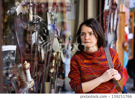 Woman tourist chooses souvenirs traditional for city of Toledo. Spain Woman tourist chooses souvenirs traditional for city of Toledo. Spain 139251766