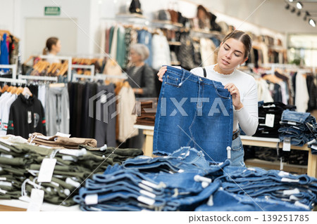 Young girl choosing jean skirt in clothing store 139251785