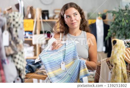 Young woman choosing vest in clothing store Young woman choosing vest in clothing store 139251802