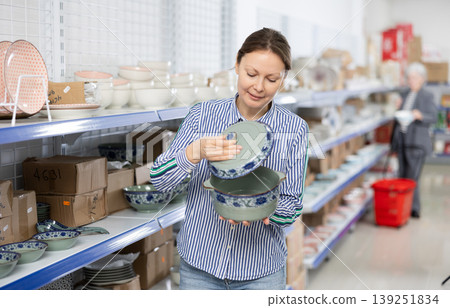 Woman customer chooses soup tureen Woman customer chooses soup tureen 139251834