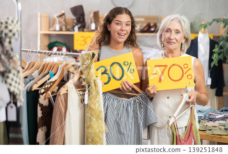 Two happy women of different ages holding sign saying discount Two happy women of different ages holding sign saying discount 139251848