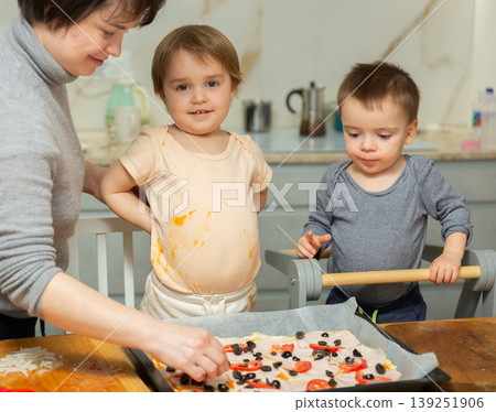 Toddler children help mom cook pizza Toddler children help mom cook pizza 139251906