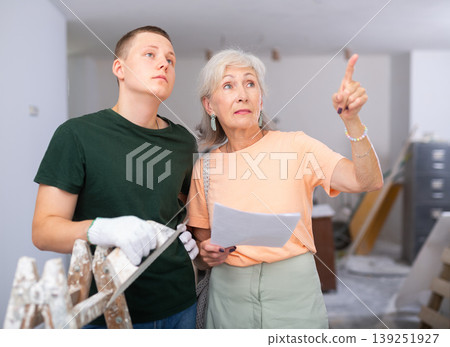 Teenager helping senior woman with home improvement works Teenager helping senior woman with home improvement works 139251927