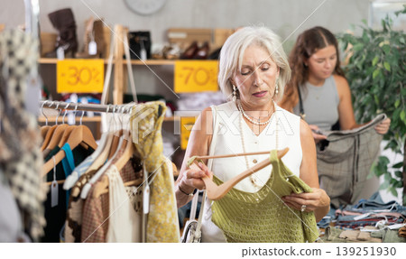 Elderly woman chooses top in clothing store 139251930
